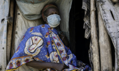 Une femme porte un masque alors qu'elle est assise devant son abri de fortune dans le camp de personnes déplacées de Kigonze à Bunia, dans l'est de la République démocratique du Congo en proie à une épidémie d'Ebola, le 28 mai 2026 ( AFP / Glody MURHABAZI )