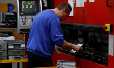 Un ouvrier plie des pièces d'acier sur une presse dans l'usine Mec Com Ltd près de Stafford