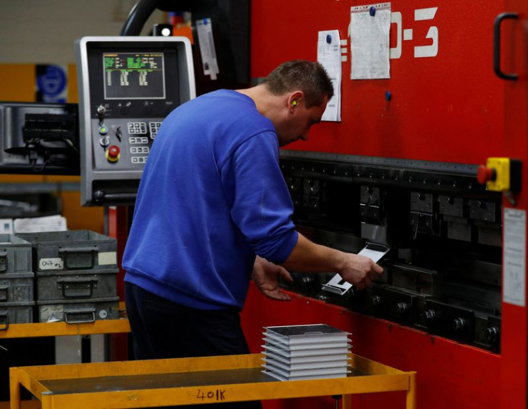 Un ouvrier plie des pièces d'acier sur une presse dans l'usine Mec Com Ltd près de Stafford