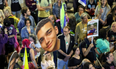 Une manifestante tient une photo géante de l'otage israélo-américain Edan Alexander, au centre, le 15 mars 2025, lors d'une manifestation à Tel Aviv, en Israël ( AFP / Jack GUEZ )