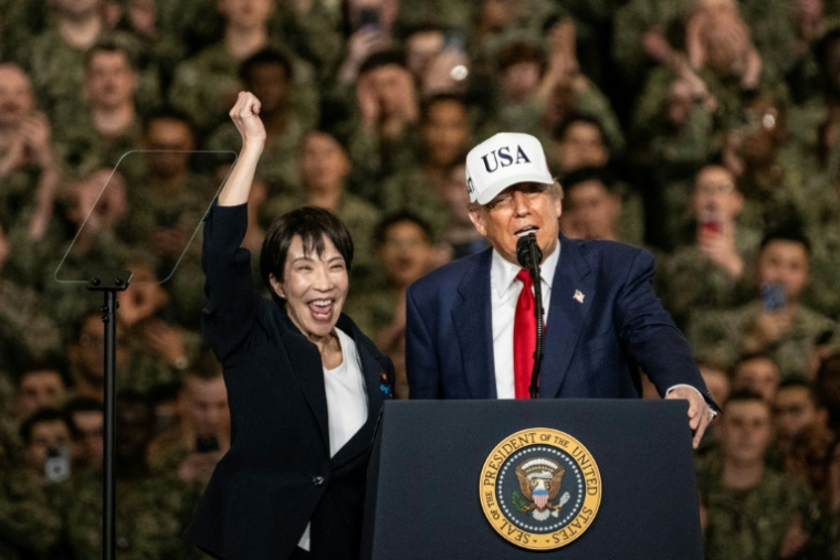 La Première ministre japonaise Sanae Takaichi (g) et le président américain Donald Trump devant le personnel de la marine américaine à bord du porte-avions USS George Washington à la base navale américaine de Yokosuka,le 28 octobre 2025 au Japon ( AFP / Philip FONG )