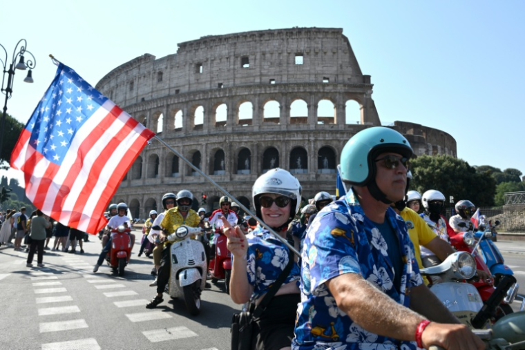 Des passionnés de Vespa du monde entier participent à la parade des Vespa World Days, marquant le 80e anniversaire de la célèbre marque italienne de scooters, le 27 juin 2026 à Rome  ( AFP / Alberto PIZZOLI )