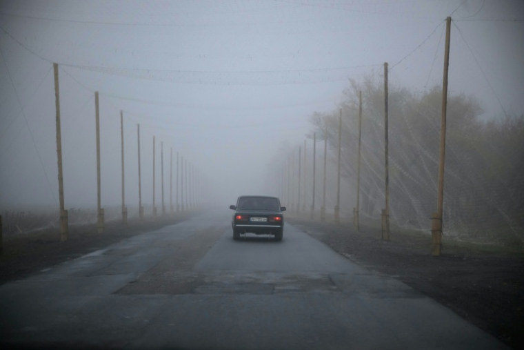 Une voiture roule sur une route protégée par des filets antidrones, près de Kramatorsk, dans l'est de l'Ukraine, le 10 octobre 2025 ( AFP / Ed JONES )