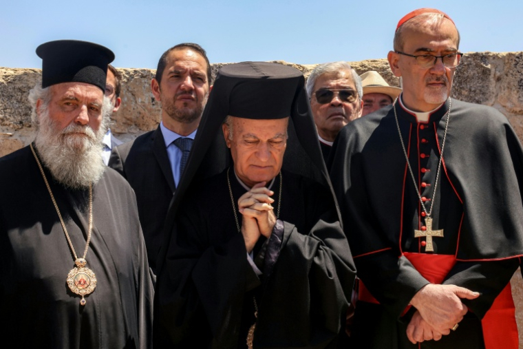 Le patriarche latin de Jérusalem, Pierbattista Pizzaballa (D), et le vicaire apostolique grec-catholique melkite de Jérusalem, Yasser Ayyash (C), à l'église Saint-Georges du Ve siècle dans le village chrétien palestinien de Taybeh, au nord-est de Ramallah en Cisjordanie occupée, le 14 juillet 2025 ( AFP / Zain JAAFAR )