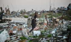Un Palestinien transporte du bois à brûler dans les ruines du camp de réfugiés de Nousseirat, dans le centre de la bande de Gaza, le 31 décembre 2025 ( AFP / Eyad Baba )