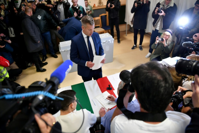 Le chef de l'opposition hongroise Peter Magyar  Peter Magyar (C), prend des bulletins de vote lors des élections législatives, le 12 avril 2026 à Budapest  ( AFP / Ferenc ISZA  )