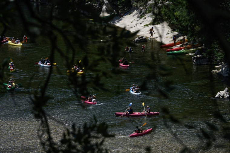Des vacanciers en canoës et kayaks sur la rivière Ardèche près de Vallon-Pont-d'Arc, le 15 juillet 2025 en Ardèche ( AFP / JEAN-PHILIPPE KSIAZEK )
