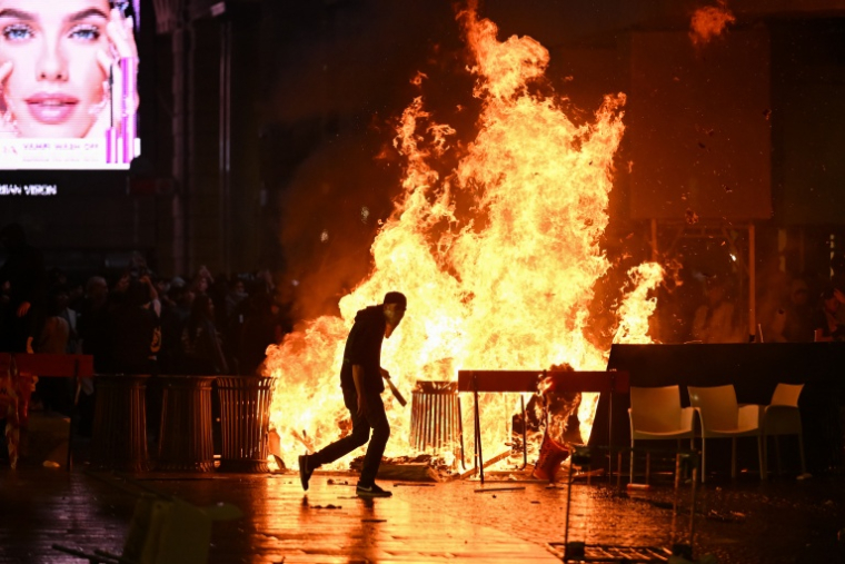 Une barricade enflammée par des manifestants lors de heurts avec la police pendant une manifestation antigouvernementale à Milan, le 17 octobre 2026 ( AFP / Piero CRUCIATTI )
