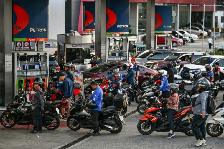 Des motocyclistes et des automobilistes font la queue à une station-service à Quezon City, dans la région métropolitaine de Manille, le 9 mars 2026 aux Philippines ( AFP / Jam STA ROSA )