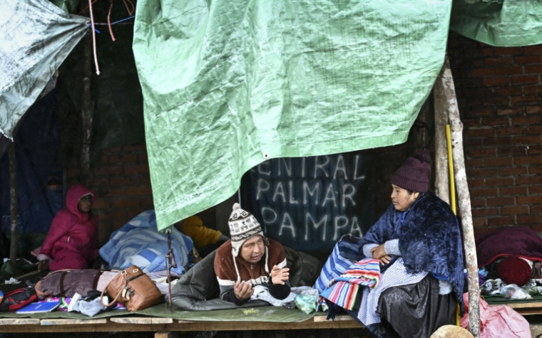 Des autochtones et habitants locaux restent dans des abris de fortune en attendant les instructions de leurs dirigeants quant à la reprise éventuelle des barrages routiers, à Lauca Ene en Bolivie, le 24 juin 2026 ( AFP / MARTIN BERNETTI )