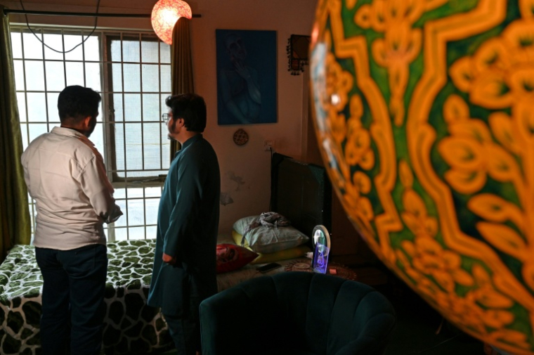 Les transgenres Zarun Ishaque (d) et Haroun dans la maison d'un ami à Islamabad, le 13 août 2025 au Pakistan ( AFP / Aamir QURESHI )