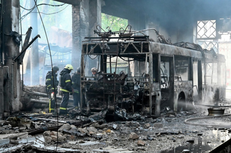 Des pompiers ukrainiens sur le site d'un incendie dans un dépôt de trolleybus après une frappe de drone russe à Kharkiv, le 30 mai 2025 ( AFP / SERGEY BOBOK )
