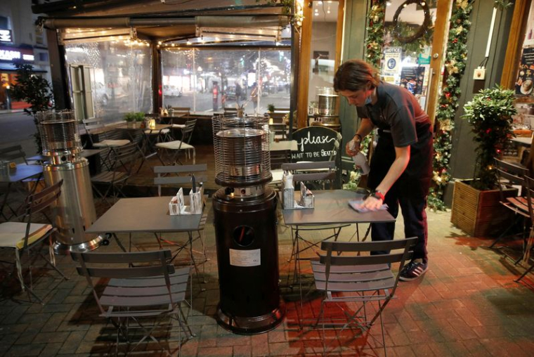 Un serveur nettoie une table dans un restaurant à Londres