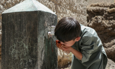 Un enfant boit de l'eau au robinet d'une fontaine à Qavariyak, dans la province de Bamiyan, le 18 juin 2025 en Afghanistan ( AFP / Mohammad Faisal NAWEED )