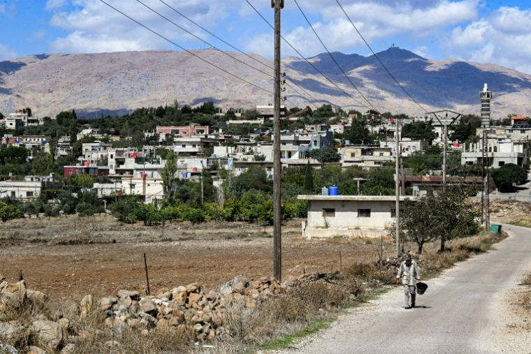 Des infrastructures militaires israéliennes (arrière-plan) surplombent le village de Jubbata al Khashab, près du Golan annexé, dans le sud-ouest de la Syrie, le 7 octobre 2026 ( AFP / LOUAI BESHARA )