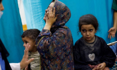 Une femme et des enfants palestiniens, blessés lors de frappes israéliennes, attendent de se faire soigner dans un hôpital de Gaza