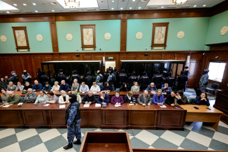 DLes accusés, soupçonnés d'implication dans l'attentat perpétré en 2024 à la salle de concert Crocus City Hall, dans des box vitrés avant l'annonce de leur verdict par un tribunal de Moscou, le 12 mars 2026 ( AFP / TATYANA MAKEYEVA )