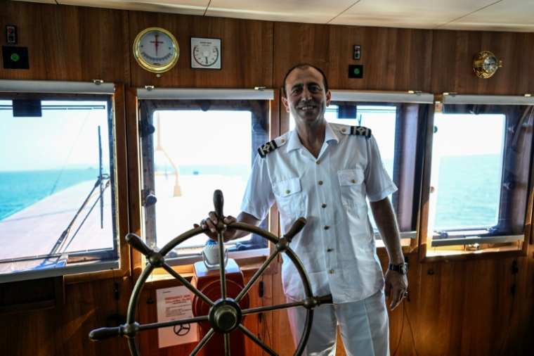 Le capitaine Ekrem Özçelik, aux commandes du ferry Pasabahçe, dans le port d'Istanbul, le 21 août 2025 en Turquie ( AFP / KEMAL ASLAN )