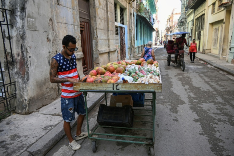 Un vendeur de rue avec un t-shirt à l'effigie du drapeau américain dans une rue de La Havane, le 18 mai 2026 ( AFP / YAMIL LAGE )