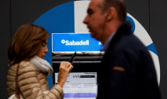 Des passants devant une agence de la banque Sabadell à Madrid