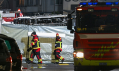 Des pompiers autour de l'autocar qui a pris feu faisant plusieurs morts, à Chiètres (Kerzers, en allemand), en Suisse, le 10 mars 2026 ( AFP / Fabrice COFFRINI )