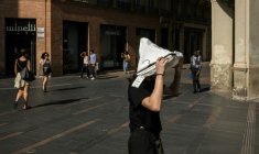 Une femme se protège du soleil avec un vêtement le 1er juillet 2025 à Toulouse lors d'une vague de chaleur ( AFP / Ed JONES )