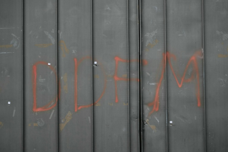 Des impacts de balles et les lettres "DDFM" peintes à la bombe sur une porte de la prison de Toulon-La Farlede, près de Toulon, après une attaque à l'arme d'assaut de type Kalachnikov, le 15 avril 2025 dans le Var ( AFP / Miguel MEDINA )