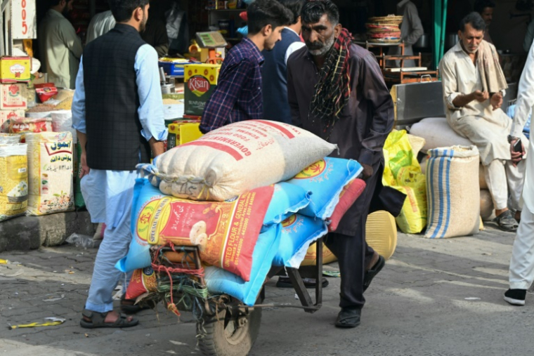 Un habitant transporte sur une brouette des sacs de nourriture au marché de Muzaffarabad, le 2 mai 2025 au Cachemire pakistanais ( AFP / Farooq Naeem )