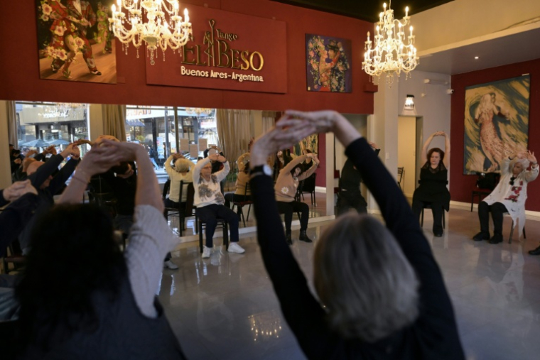 Des personnes touchées par la maladie de Parkinson s'échauffent lors d'une session de "tango-thérapie" à Buenos Aires le 26 août 2025 ( AFP / JUAN MABROMATA )