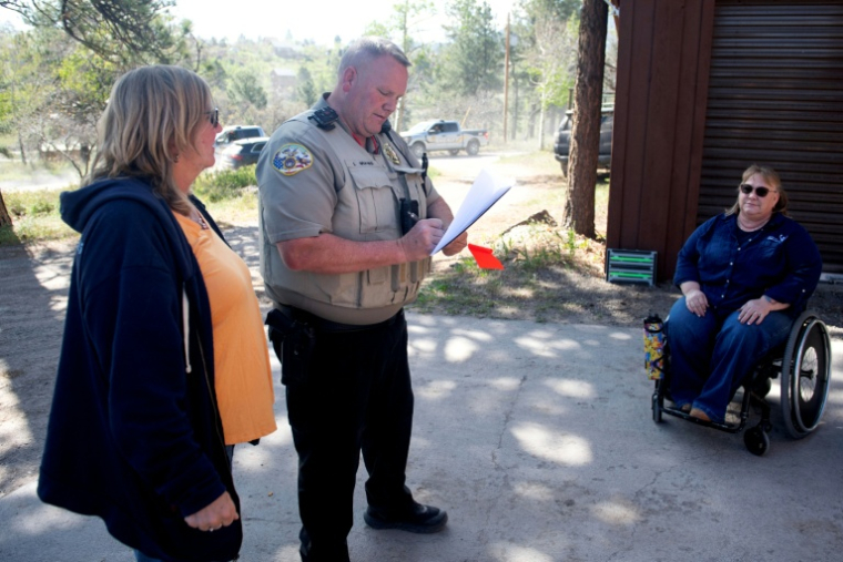 Amy Clewel, le policier Larry Graves and Jennifer Shook lors d'un exercice d'évacuation dans un quartier du comté d'Ouray dans le Colorado américain, le 15 mai 2026 ( AFP / Jason Connolly )