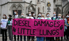 Des manifestants rassemblés devant la Haute Cour à Londres, à l'ouverture du procès de cinq géants de l'automobile impliqués dans le scandale des voitures diesel truquées, le 13 octobre 2025 ( AFP / CARLOS JASSO )