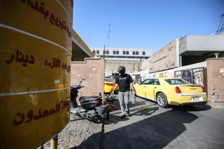 Un homme porte un bidon d'essence à l'entrée d'une station-service à Bagdad, le 5 septembre 2026 en Irak ( AFP / MURTAJA LATEEF )