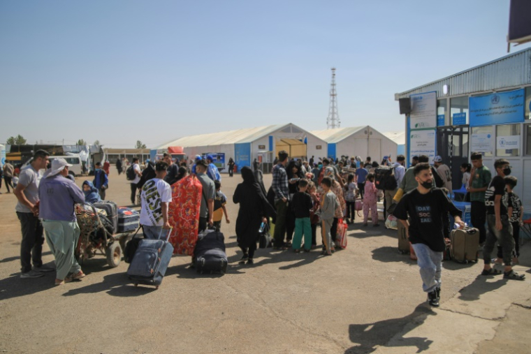 Des réfugiés afghans arrivent avec leurs biens après avoir traversé la frontière avec l'Iran, à Islam Qala, dans la province d'Herat, le 24 juillet 2025 en Afghanistan ( AFP / Mohsen KARIMI )