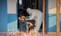Un professionnel de santé avec un patient atteint de la maladie à virus Ebola au centre de traitement d'Ebola du Centre médical évangélique (CME), à Bunia, dans la province de l'Ituri, à l'est de la République démocratique du Congo, le 23 juin 2026. ( AFP / Benediction MURHABAZI )