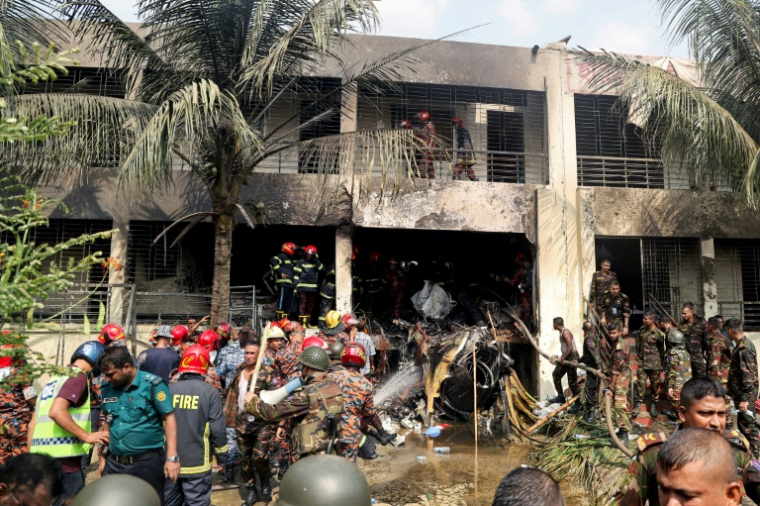 Secouristes et pompiers sur les lieux du crash d'un avion militaire, tombé sur une école à Dacca, le 21 juillet 2025 ( AFP / Abdul Goni )