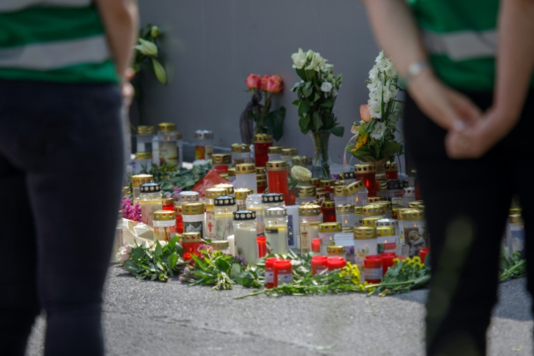 Des fleurs et des bougies déposées devant l'établissement scolaire de Graz, où dix personnes ont été tuées par balles la veille, le 11 juin 2025 en Autriche ( AFP / Alex HALADA )