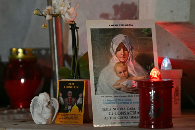 Des fleurs et des bougies déposées devant l'hôpital Gemelli où est hospitalisé le pape Léon XIV, le 13 octobre 2026 à Rome ( AFP / Andreas SOLARO )