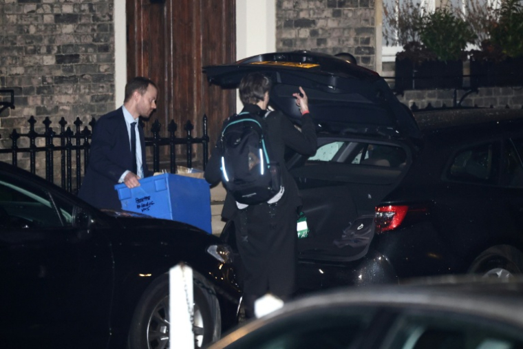 Un policier transportant un carton de documents sort de la résidence de l'ex-ministre et ancien ambassadeur britannique, Peter Mandelson, dans le centre de Londres, le 6 février 2026 ( AFP / Henry NICHOLLS )