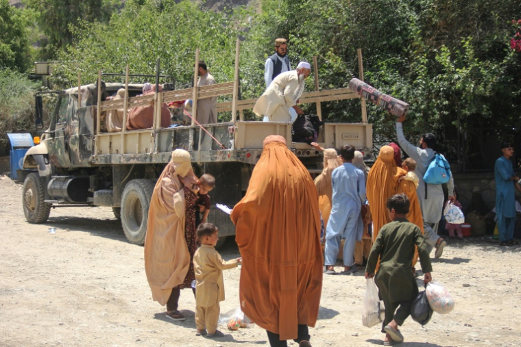 Des rapatriés afghans chargent leurs affaires dans un camion militaire à leur arrivée du Pakistan, à Torkham, le 24 juin 2026 ( AFP / Aimal ZAHIR )
