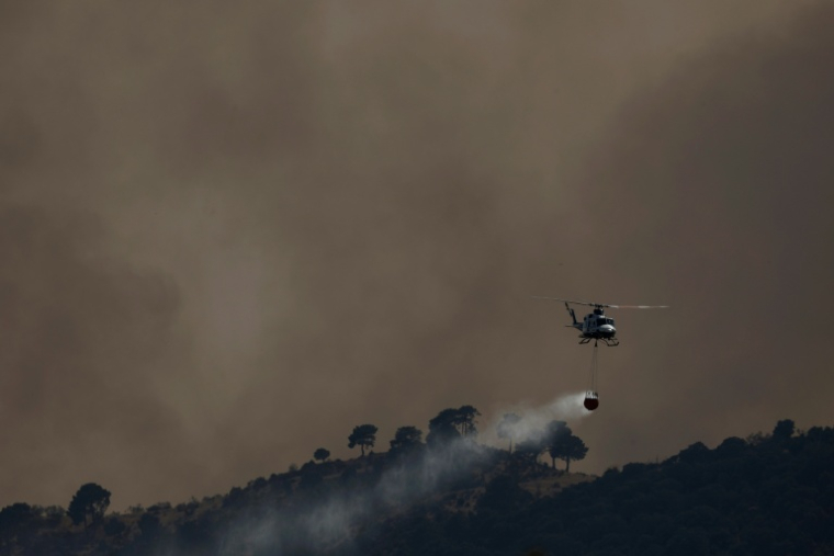 Un hélicoptère bombardier d’eau largue de l’eau sur un incendie de forêt près de Robledo de Chavela, à environ 60 kilomètres à l’ouest de Madrid, le 27 juillet 2026 ( AFP / Oscar DEL POZO )