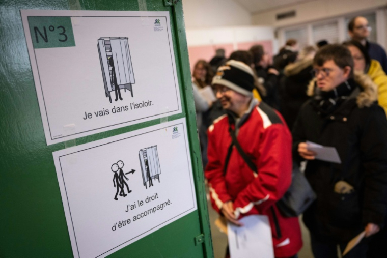 Des personnes en situation de handicap intellectuel patientent avant d'entrer dans un isoloir lors d'un faux scrutin organisé le 17 février 2026 à Saint-Dié-des-Vosges ( AFP / SEBASTIEN BOZON )