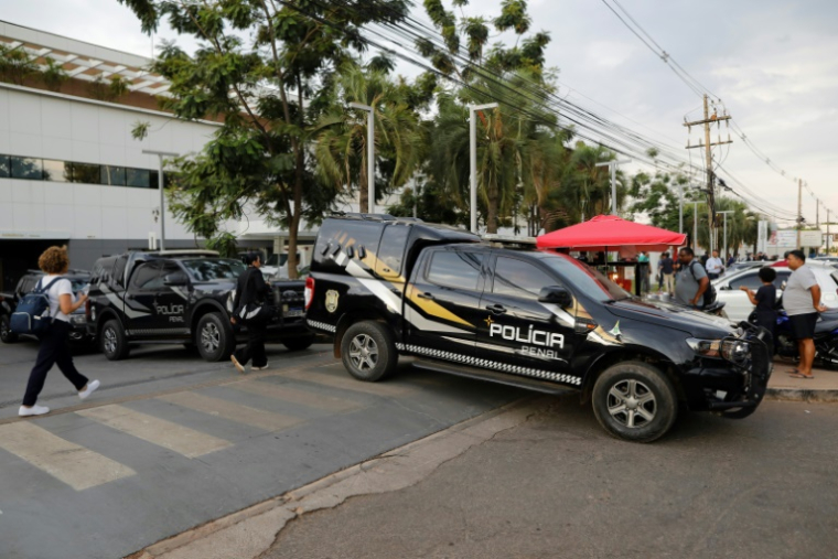 Des véhicules de la police stationnées à l'extérieur de l'hôpital DF Star de Brasilia où l'ancien président brésilien Jair Bolsonaro a été admis après un malaise à son domicile, le 16 septembre 2025 ( AFP / Sergio Lima )