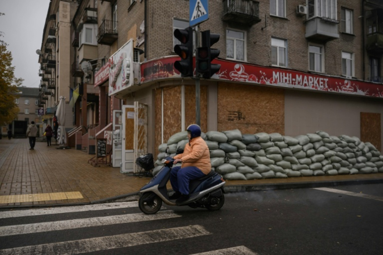 Dans une rue de Droujkivka, aux façades masquées par des panneaux de bois en cas de bombardements, dans l'est de l'Ukraine, le 10 octobre 2025 ( AFP / Ed JONES )