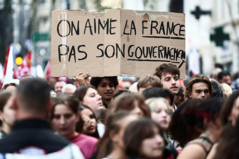 Des manifestants brandissent une pancarte sur laquelle on peut lire "On aime la France, pas son gouvernement", le 29 septembre 2026 à Marseille ( AFP / Thibaud MORITZ )