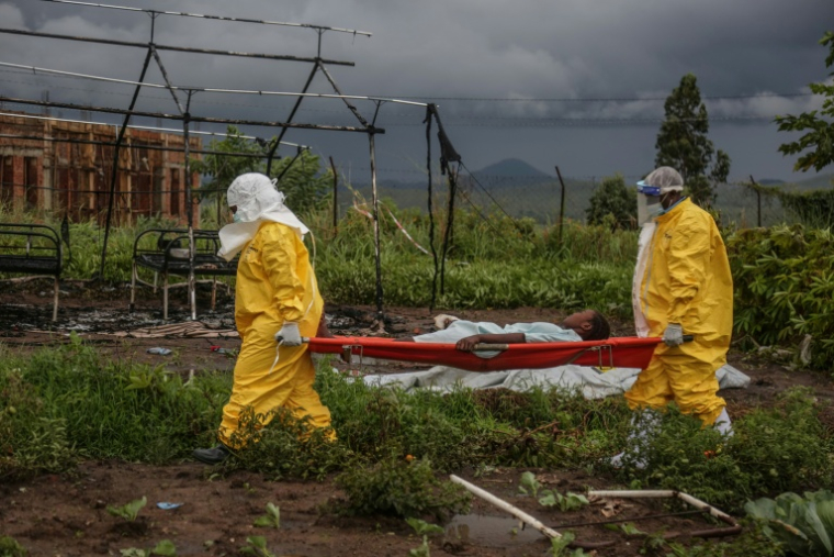 Du personnel médical transporte un patient sur un brancard à l'hôpital de Rwampara, le 21 mai 2026, en OUganda, tout près de la République Démocratique du Congo, touchée par une épidémie d'Ebola ( AFP / Seros MUYISA )