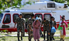 Des militaires soutiennent une rescapée, au camp de Trishuli, dans le district de Nuwakot au Népal, le 28 août 2026 ( AFP / Arun SANKAR )