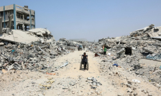 Un garçon palestinien tire un fauteuil roulant au milieu des dstructions dans le quartier al-Touffah de la ville de Gaza, le 14 août 2025 ( AFP / Omar AL-QATTAA )