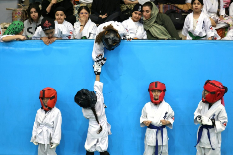 Des karatékas iraniennes en bas âge patientent avant le début d'une compétition féminine régionale à Téhéran, le 5 novembre 2025. ( AFP / ATTA KENARE )