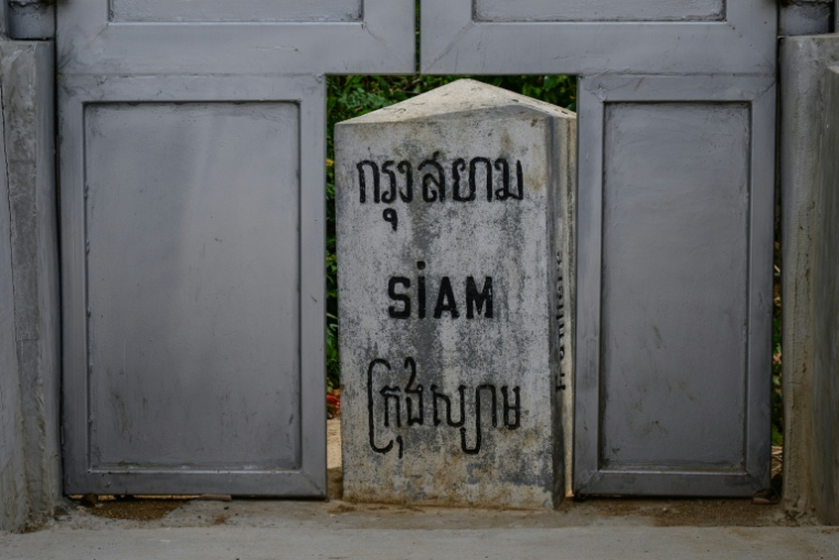 Une borne marquée "Siam", érigée à l'époque coloniale française, visible dans une ouverture d'u, mur en béton installé par l'armée thaïlandaise, le long de la frontière entre la Thaïlande et le Cambodge, dans le district de Pong Nam Ron, le 10 septembre 2026 en Thaïlande ( AFP / ANTHONY WALLACE )