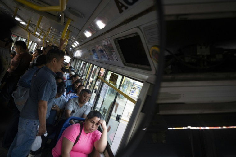 Des passagers à bord d'un bus dans le district populaire de San Juan de Lurigancho, le 8 avril 2026 à Lima ( AFP / ERNESTO BENAVIDES )